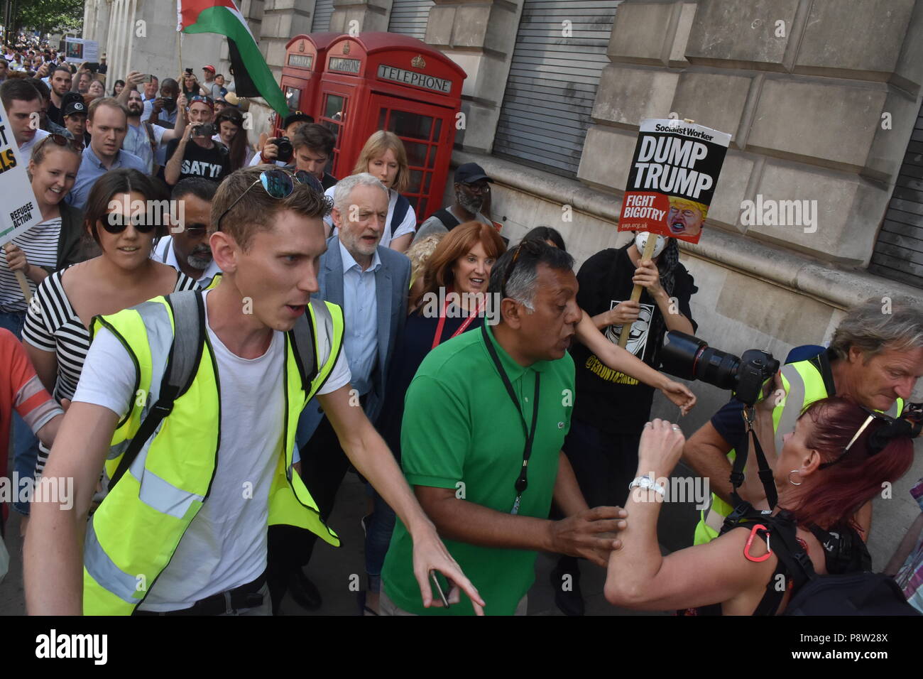 London's beloved leader of the Labour party Jeremy Corbyn takes to the streets of London on foot with very little security as he makes his way towards Leicester Square where he gave a speech in front of the thousands of people who had descended upon London today to protest the visit from American President Donald Trump. Corbyn was greeted with smiles and cheers as he once again literally rubbed shoulders with the people of London as he made his way while the crowd sang his name repeatedly along  Parliament Street past Whitehall towards the Trump protesters Stock Photo