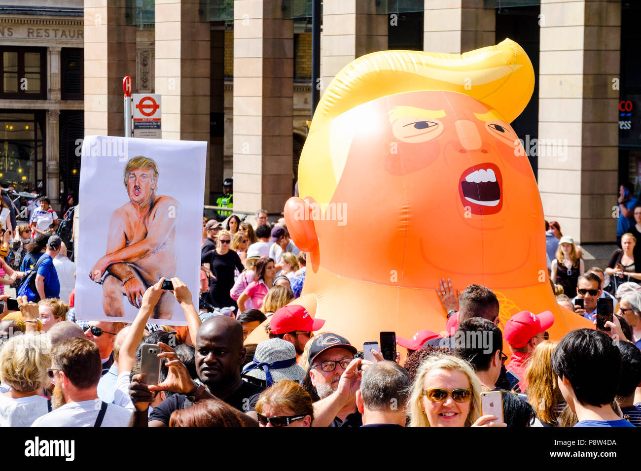 London, UK. 13th July 2018. Tens of thousands of people took to the streets of central London to protest against US President Donald Trump's visit to the UK. Pictured: A reproduction of Illma Gore's portrait of Donald Trump alongside a baby Trump inflatable during the London protests. Credit: mark phillips/Alamy Live News Stock Photo
