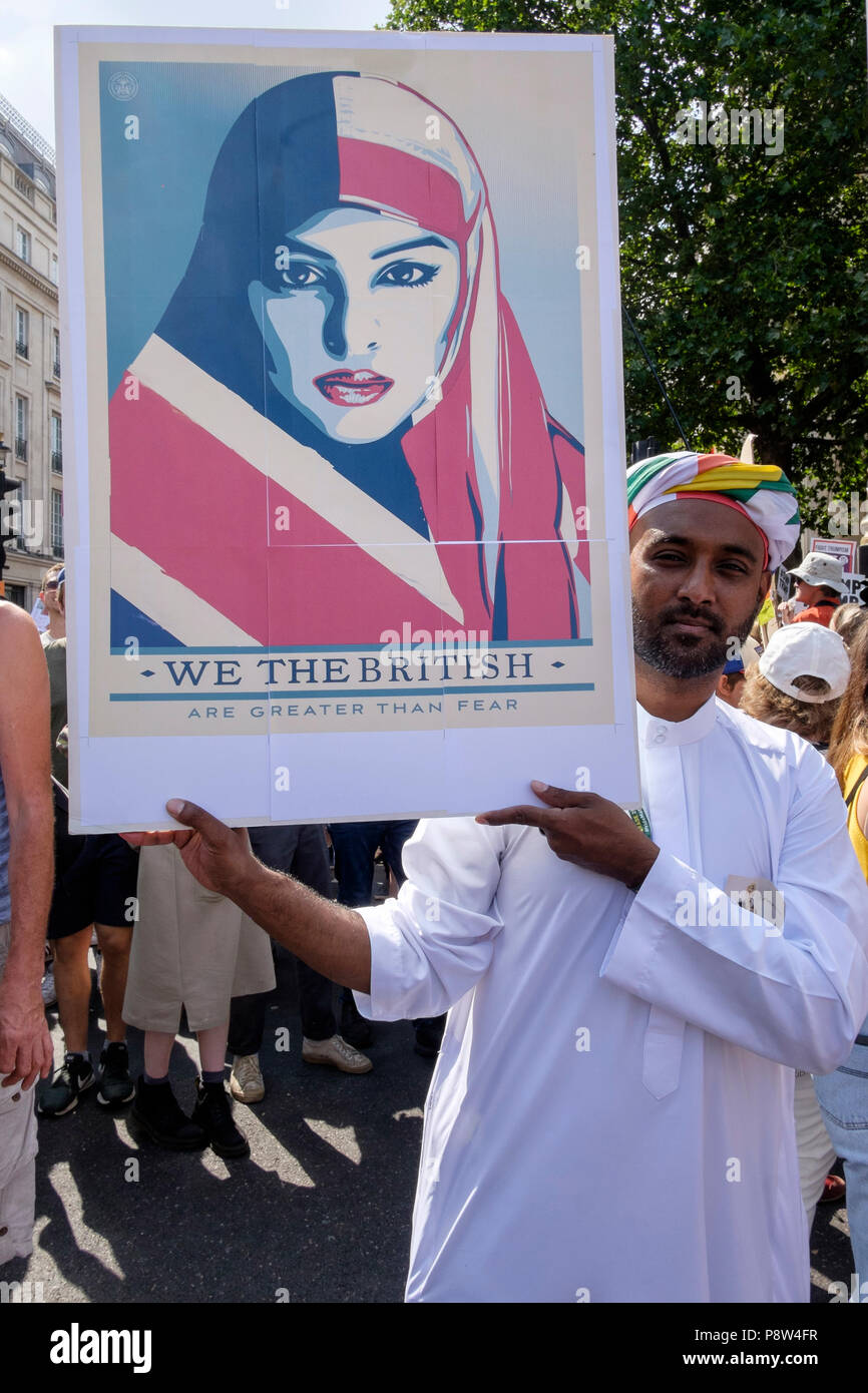 London, UK. 13th July 2018. Tens of thousands of people took to the streets of central London to protest against US President Donald Trump's visit to the UK. Pictured: A man holds an adapted version of Shepard Fairey's Greater Than Fear, screenprint  depicting a Muslim woman adorned by a Union flag. Credit: mark phillips/Alamy Live News Stock Photo