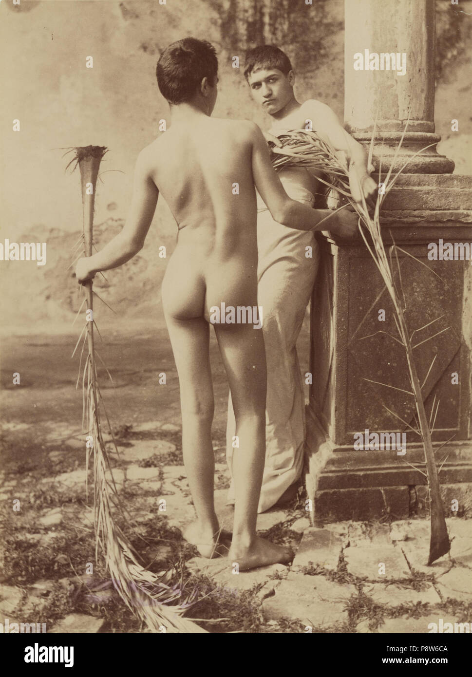 .   51 Baron Wilhelm von Gloeden (German - Untitled (Two Male Youths Holding Palm Fronds) - Stock Photo