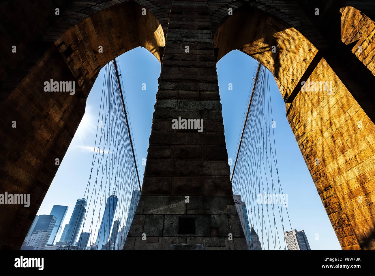 Looking back at the New York skyline through the arches of a bridge. Stock Photo