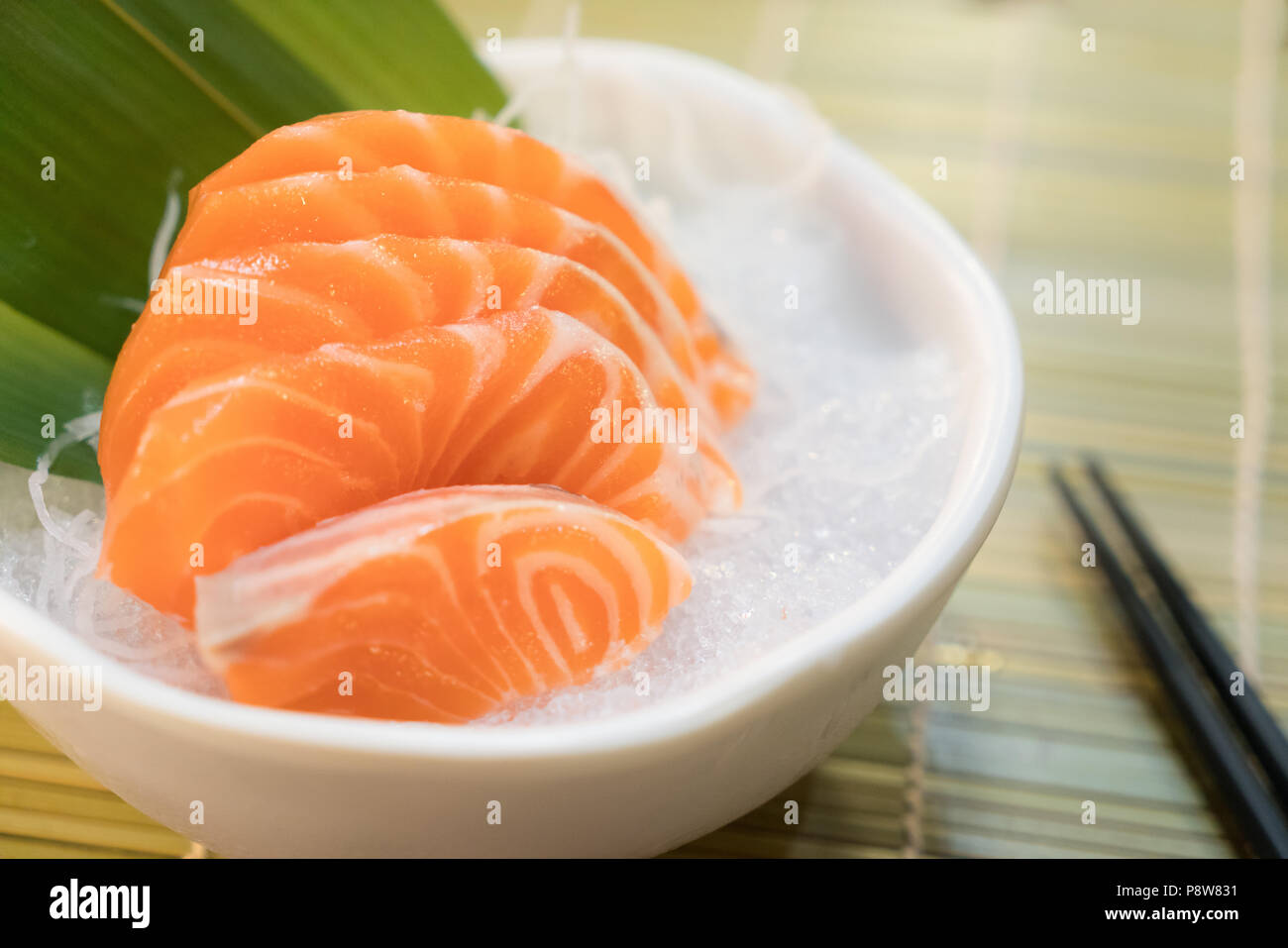 Raw salmon slice or salmon sashimi in Japanese style fresh serve on ice in bowl. Stock Photo