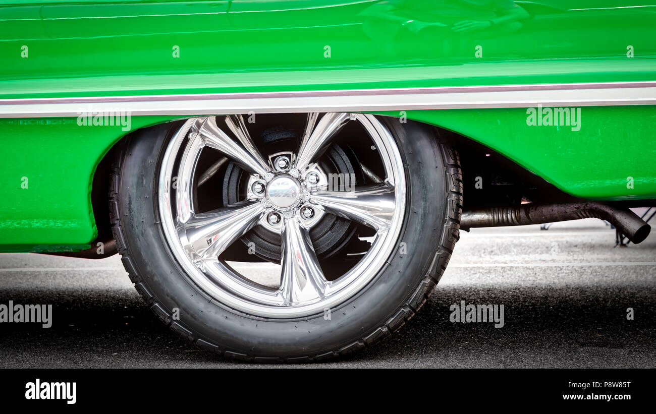 A classic American car, with updated hubcaps, from the sixties in green. Stock Photo