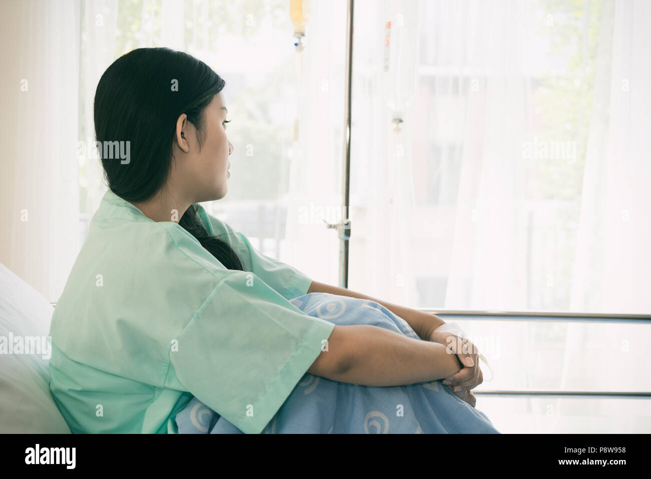 Asian stress patients woman looking outside the window, Patients is glad recovered from the illness. Stock Photo