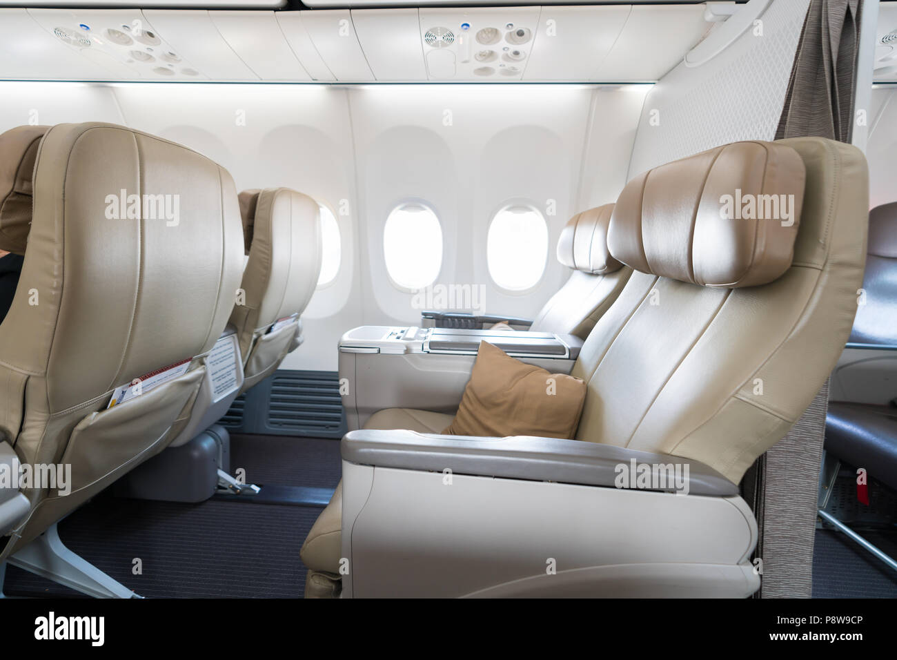 Empty leather seats in row atBusiness class reclined seats of airplane. Stock Photo