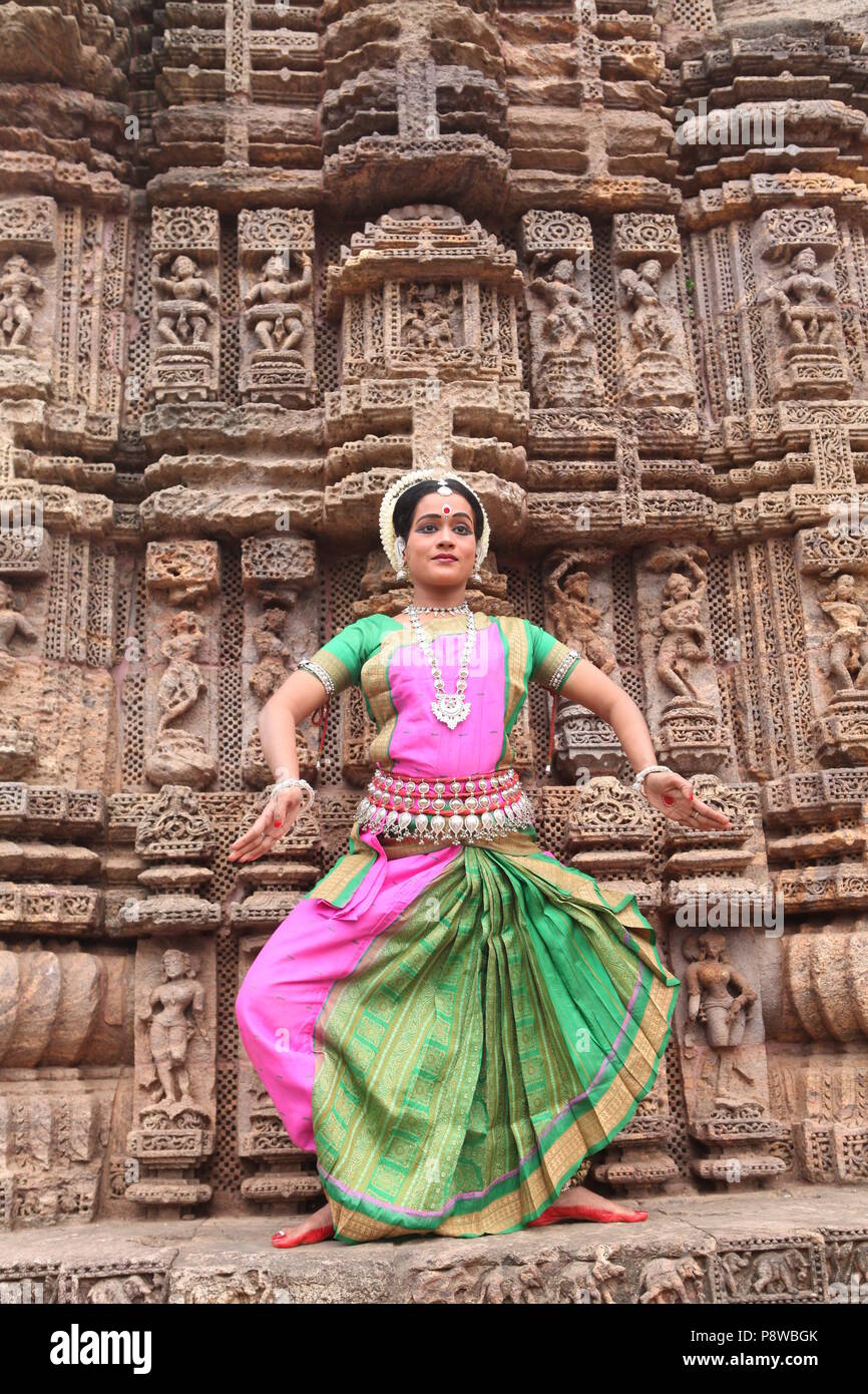 odissi is one of the eight classical dance forms of india,from the state of odisha.here the dancer poses before temples with sculptures Stock Photo
