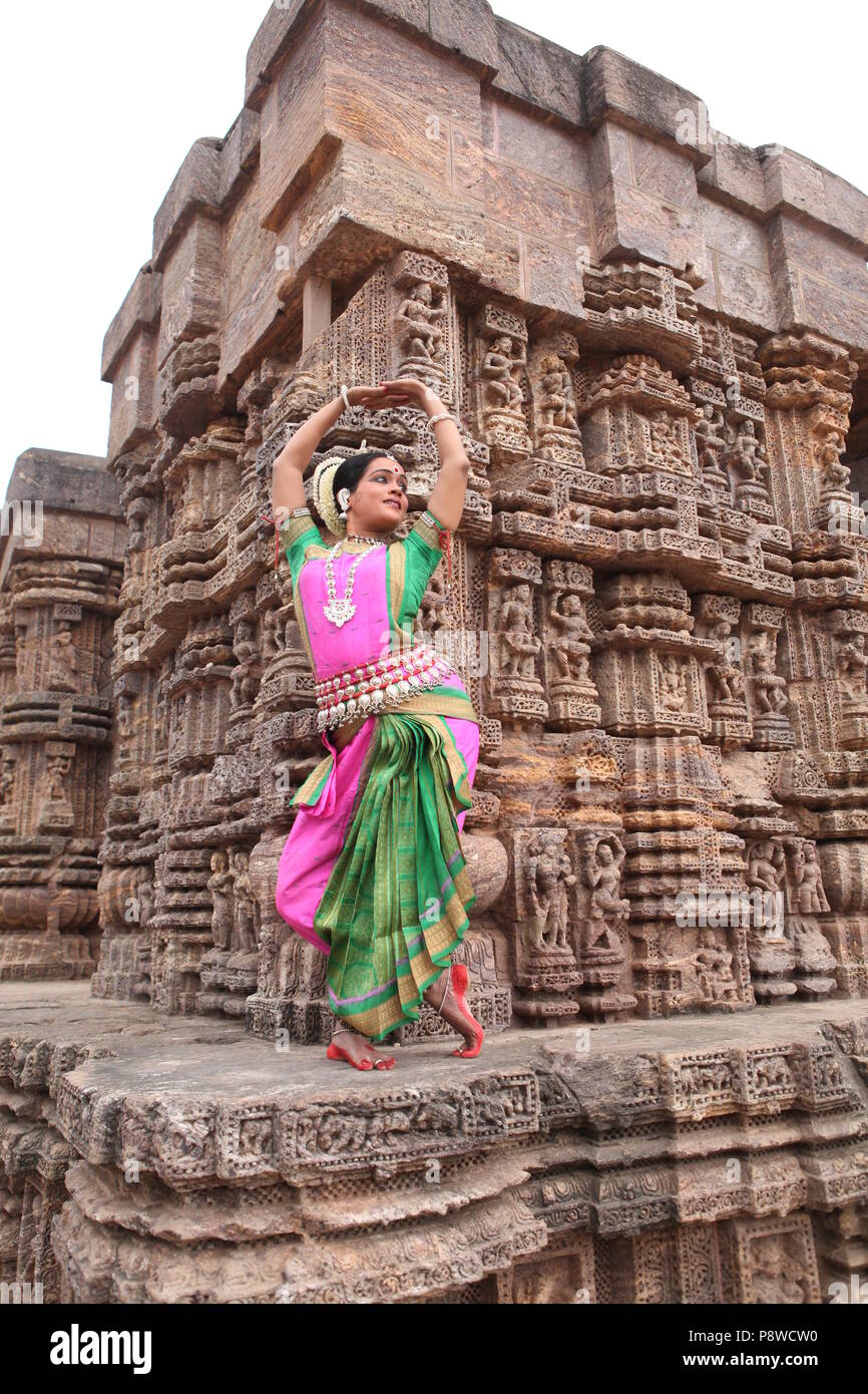 odissi is one of the eight classical dance forms of india,from the state of odisha.here the dancer poses before temples with sculptures Stock Photo