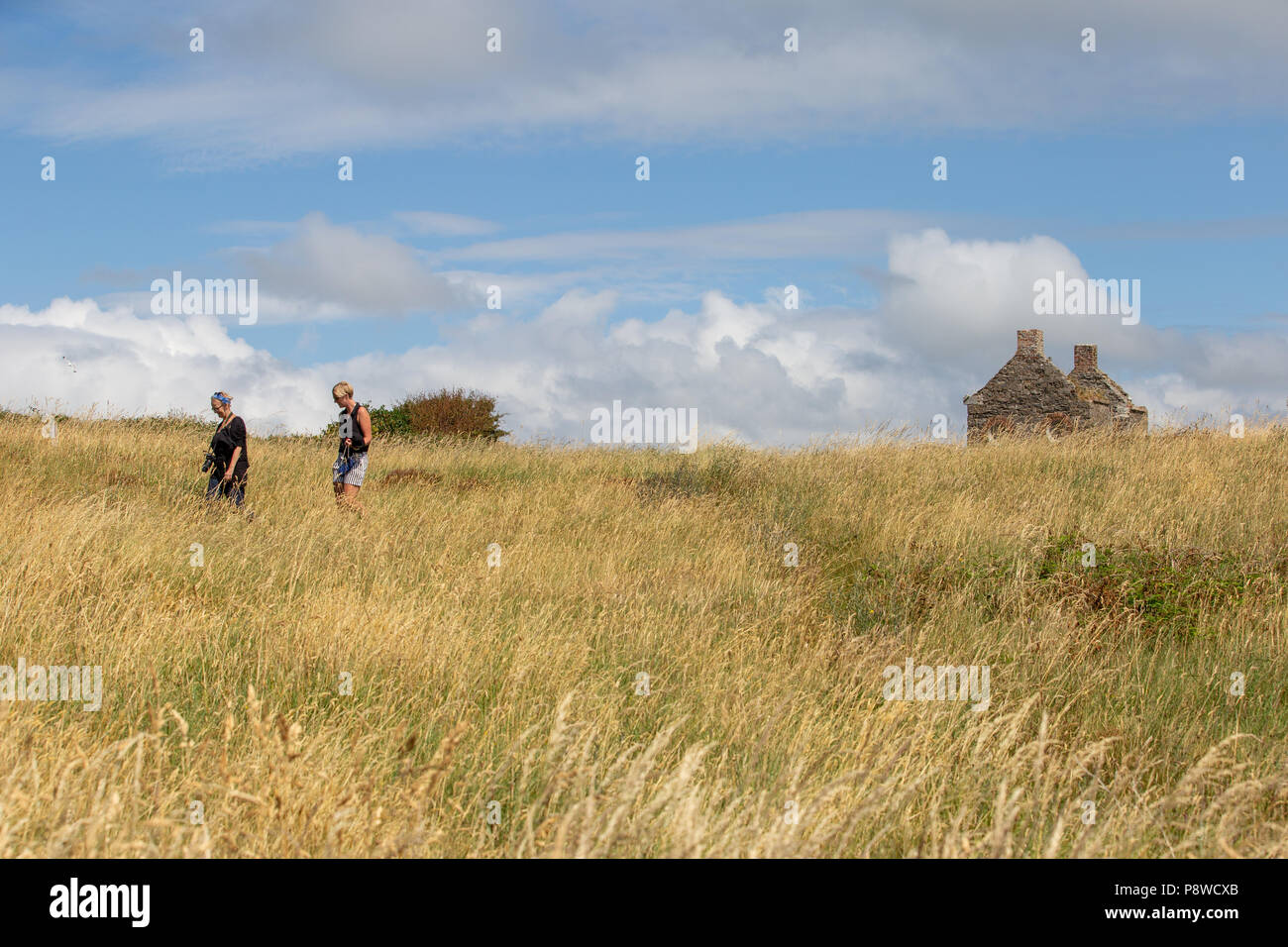 Tourists at the abandoned Old Watchhouse with circle windows at the Rosses Point used by Sligo River Pilots to watch for sailing ships. Stock Photo