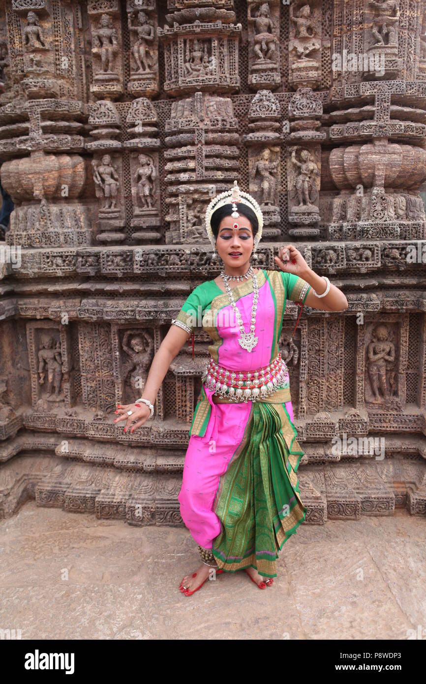 odissi is one of the eight classical dance forms of india,from the state of odisha.here the dancer poses before temples with sculptures Stock Photo