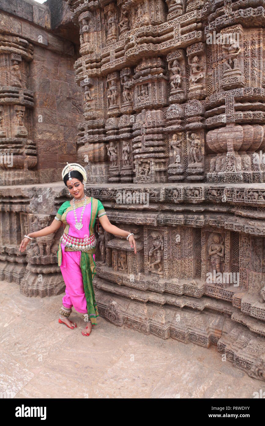 odissi is one of the eight classical dance forms of india,from the state of odisha.here the dancer poses before temples with sculptures Stock Photo