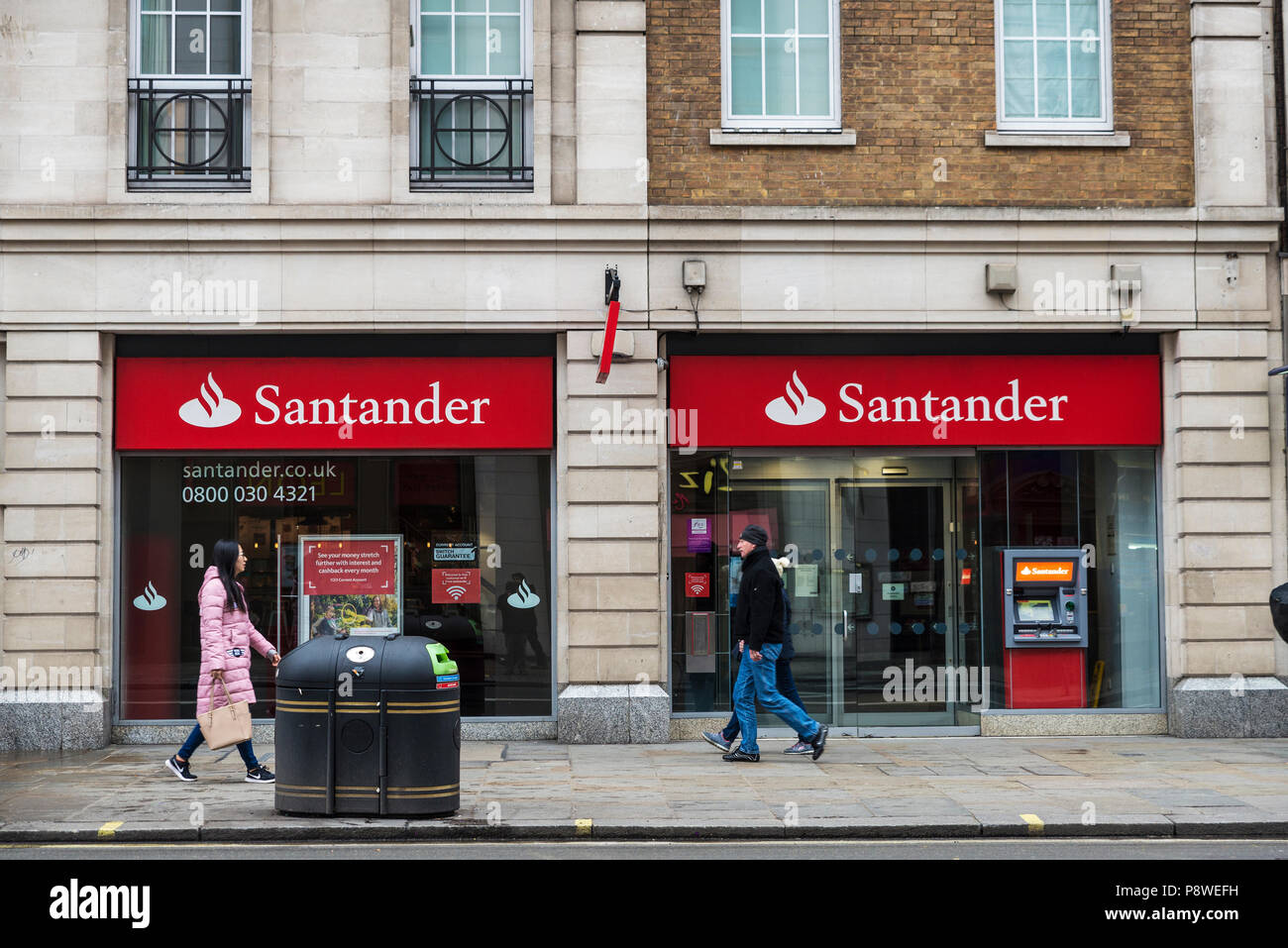 London, United Kingdom - January 1, 2017: Bank branch and ATM of Santander Bank with people around in London, England, United Kingdom Stock Photo