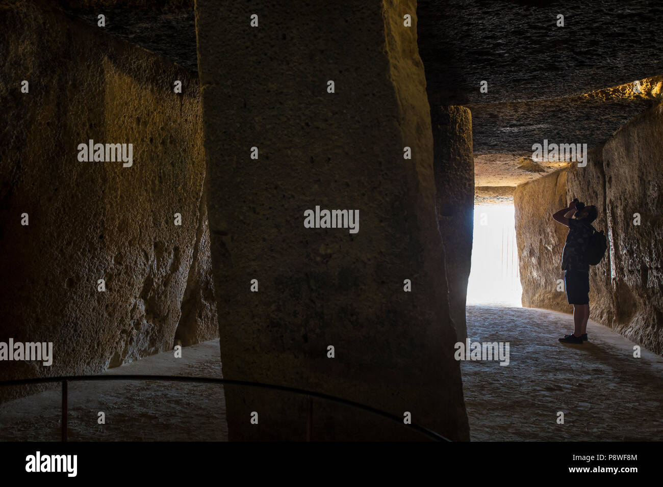 Antequera, Spain - July 10th, 2018: Visitor takes pictures at interior chamber of Dolmen of Menga, Antequera, Spain Stock Photo