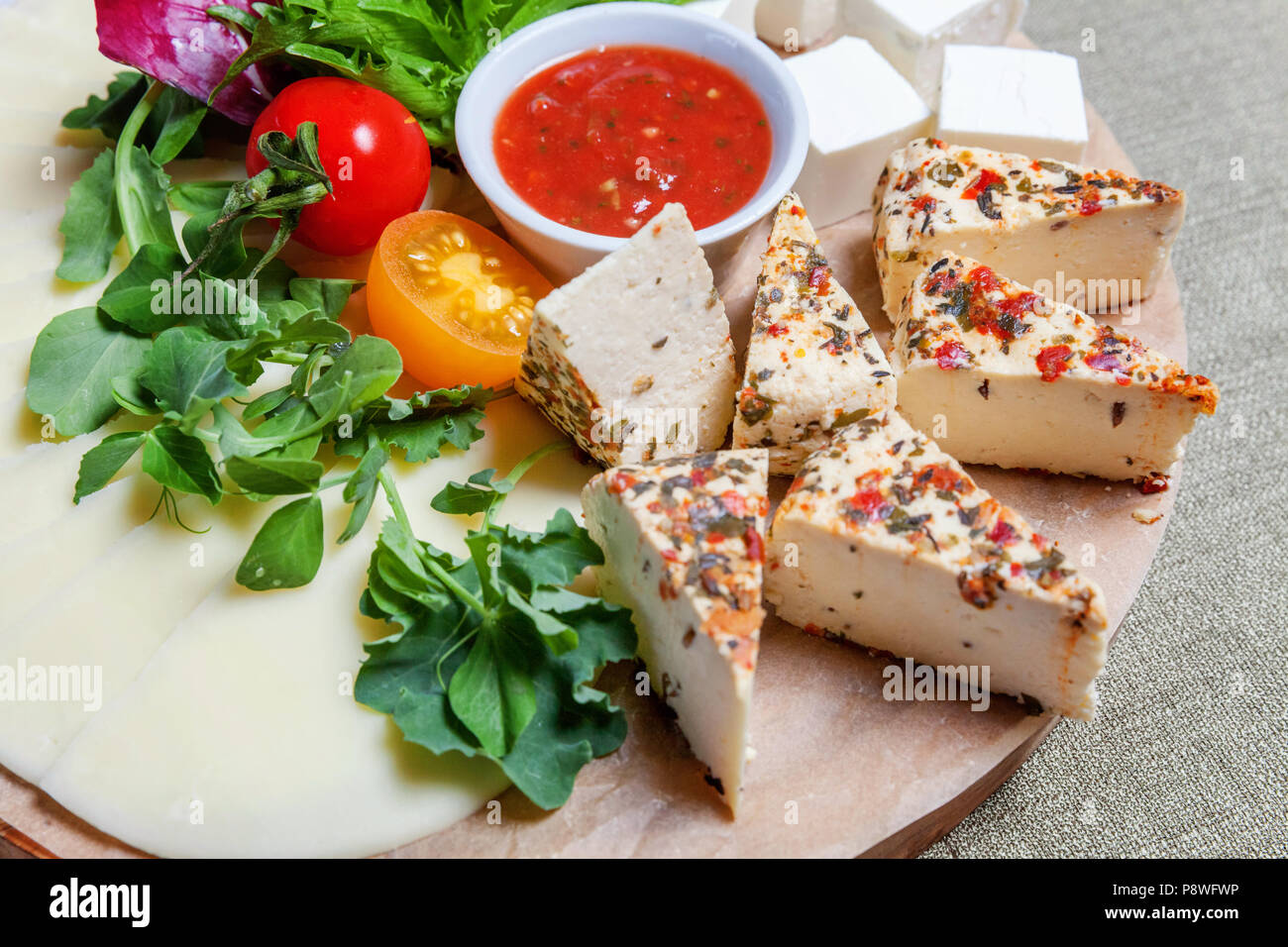 Board with different types of cheese fetabrynza, tomato sauce and