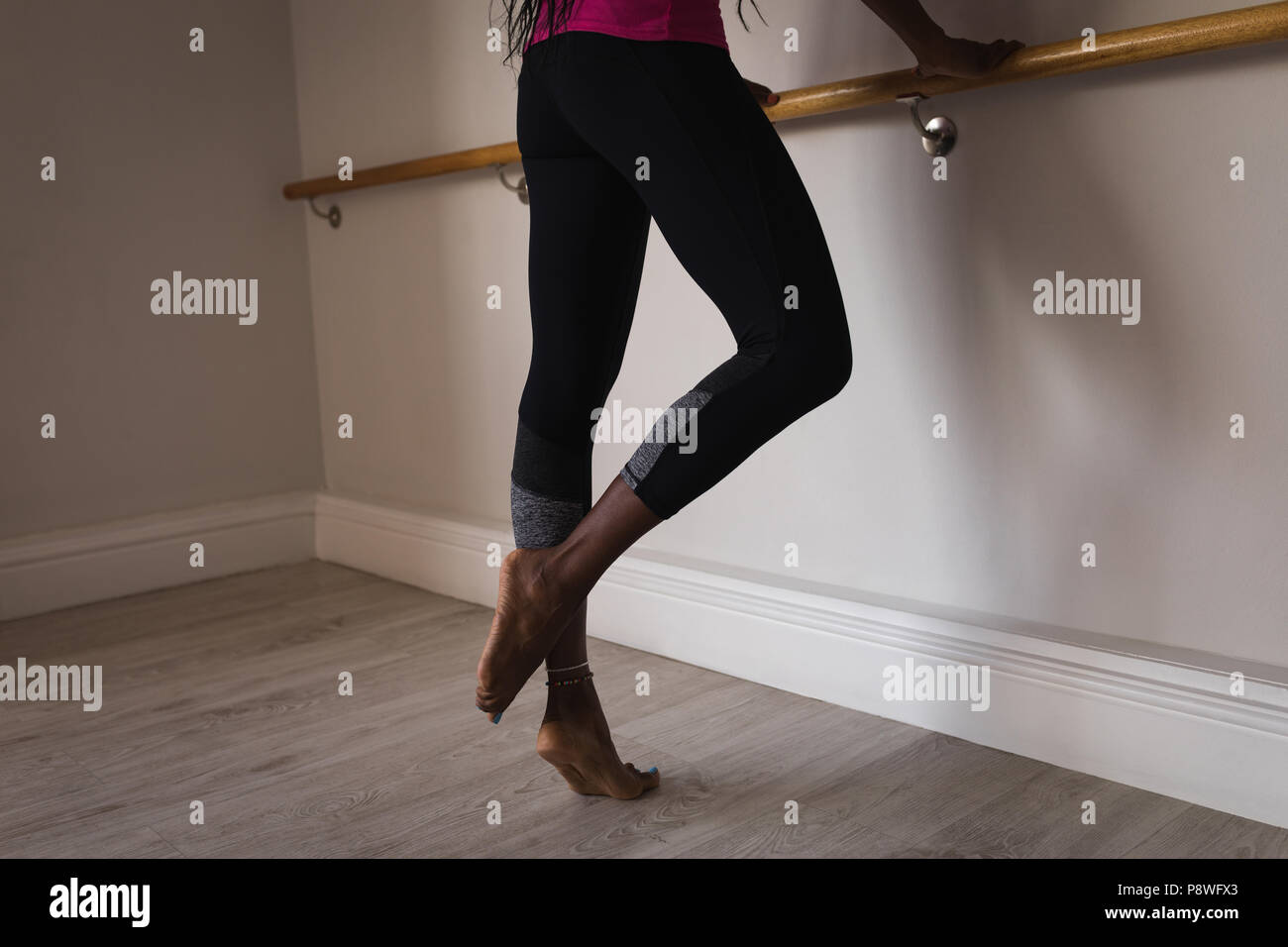 Woman performing barre exercise Stock Photo
