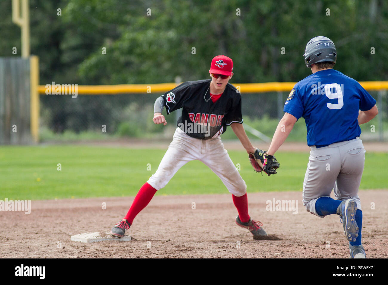 Baseball runner coming into second base, boys afternoon junior baseball game. Cranbrook, BC. Stock Photo