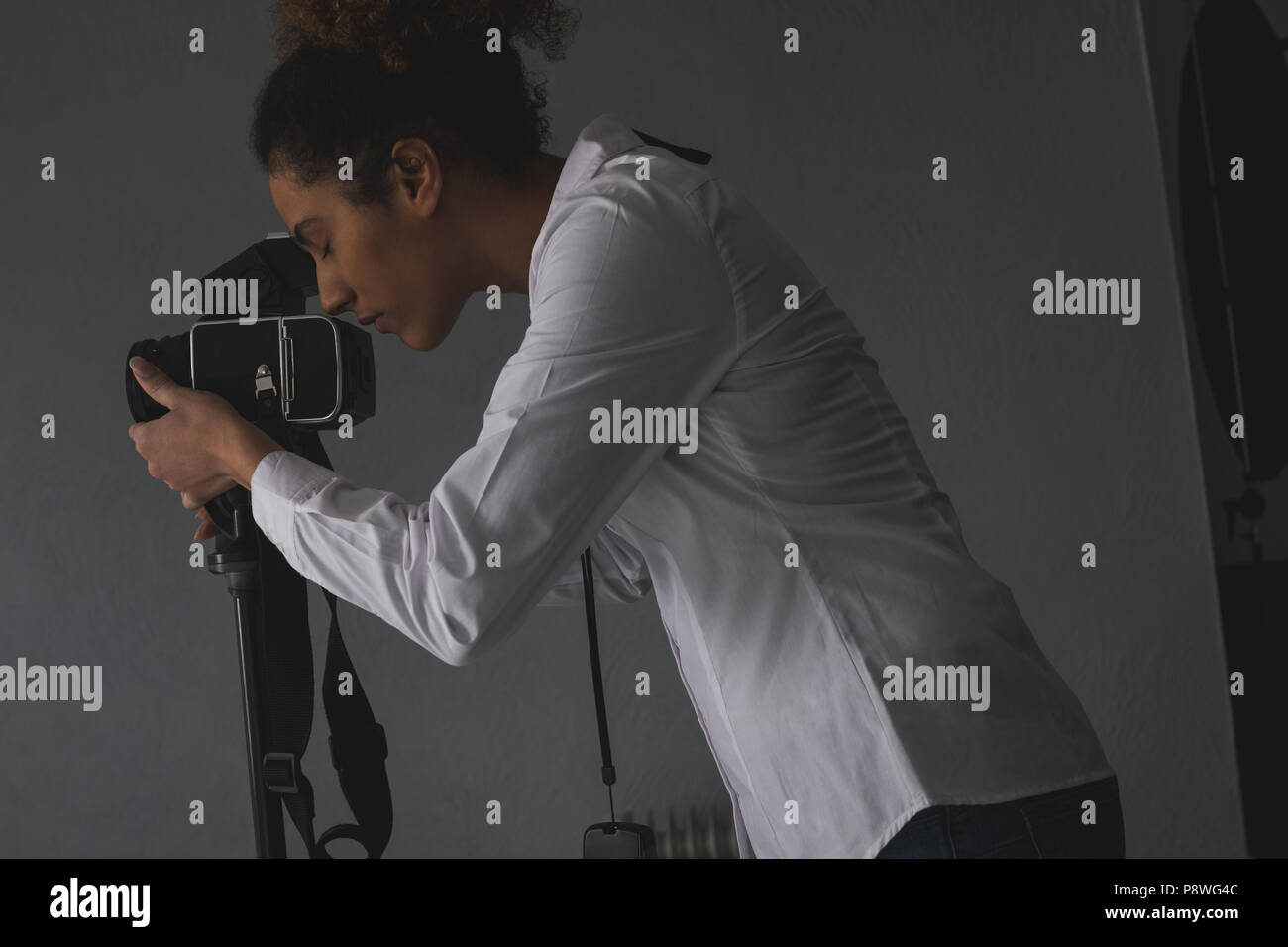 Female photographer clicking photos with digital camera Stock Photo