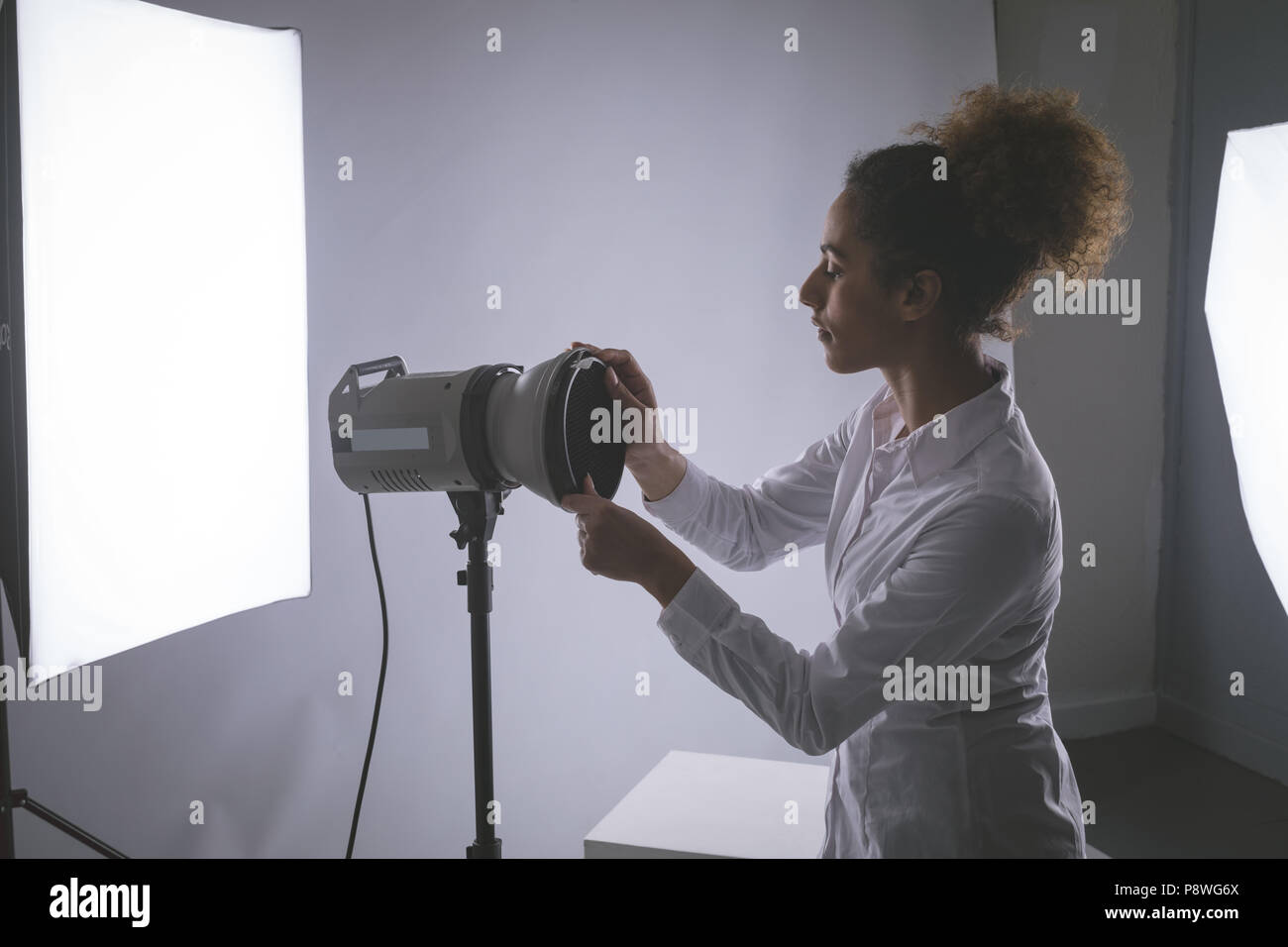 Female photographer adjusting strobe lights Stock Photo Alamy