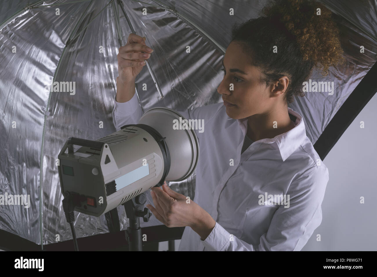 Female photographer adjusting strobe lights Stock Photo Alamy