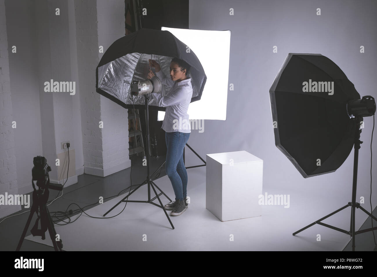 Female photographer adjusting strobe lights Stock Photo Alamy