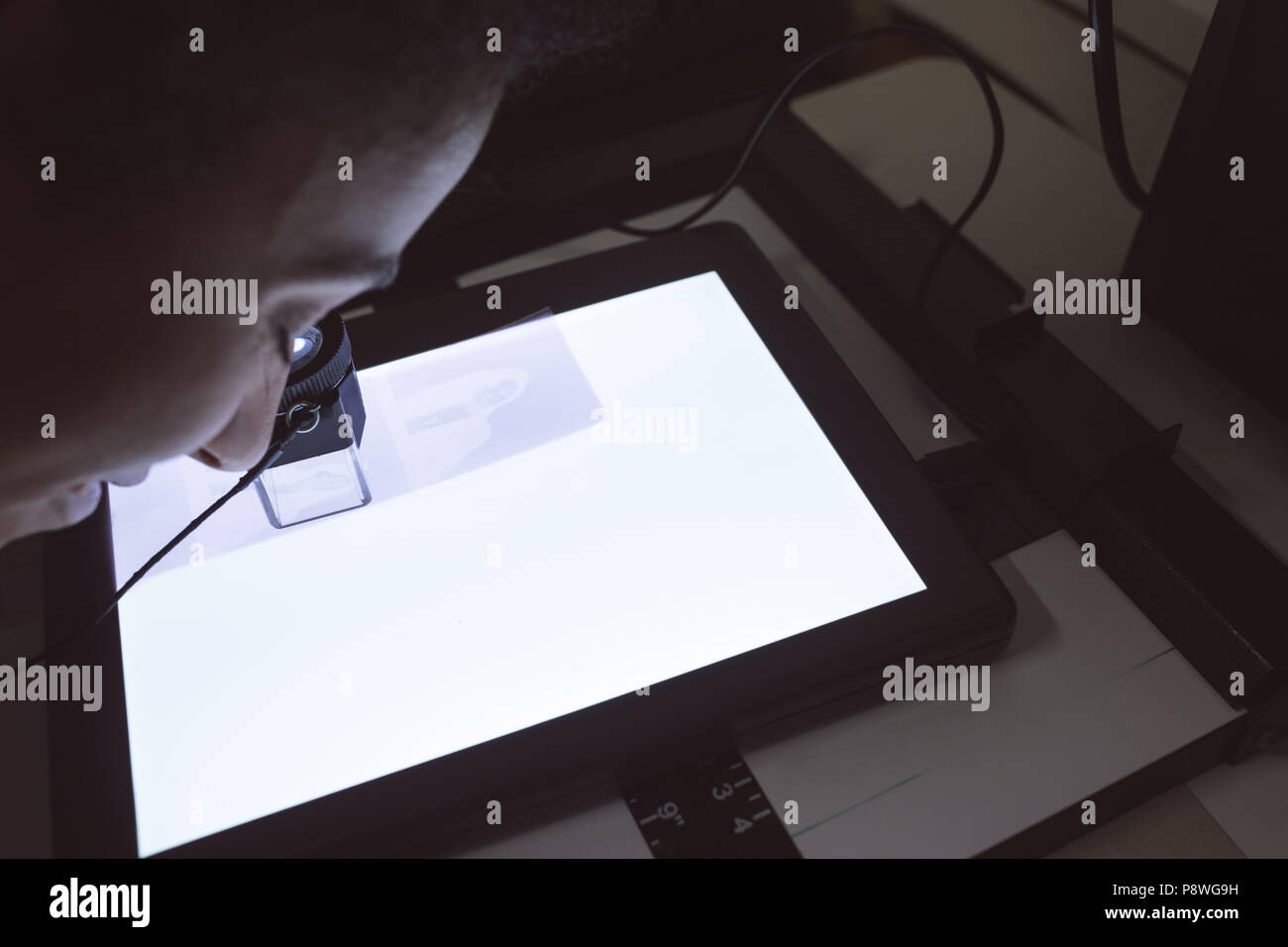 Female photographer using pocket magnifier Stock Photo