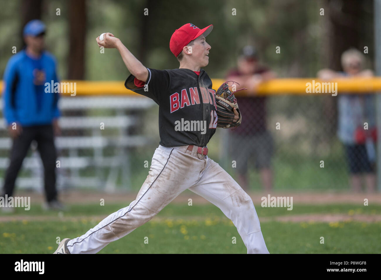 Pitcher delivering pitch, in full stride, showing grip, boys afternoon