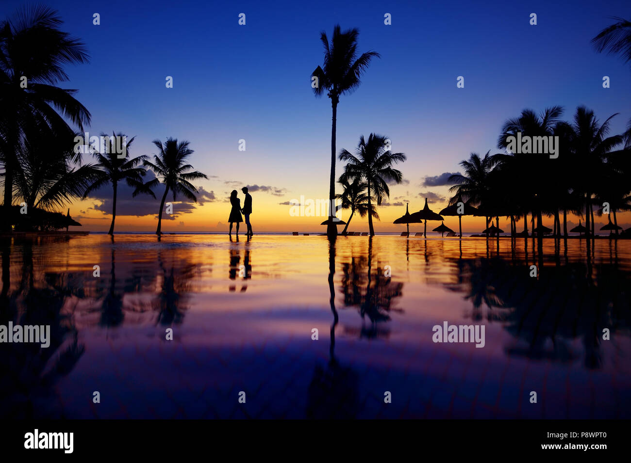 Silhouettes of young couple at scenic sunset on tropical beach Stock ...