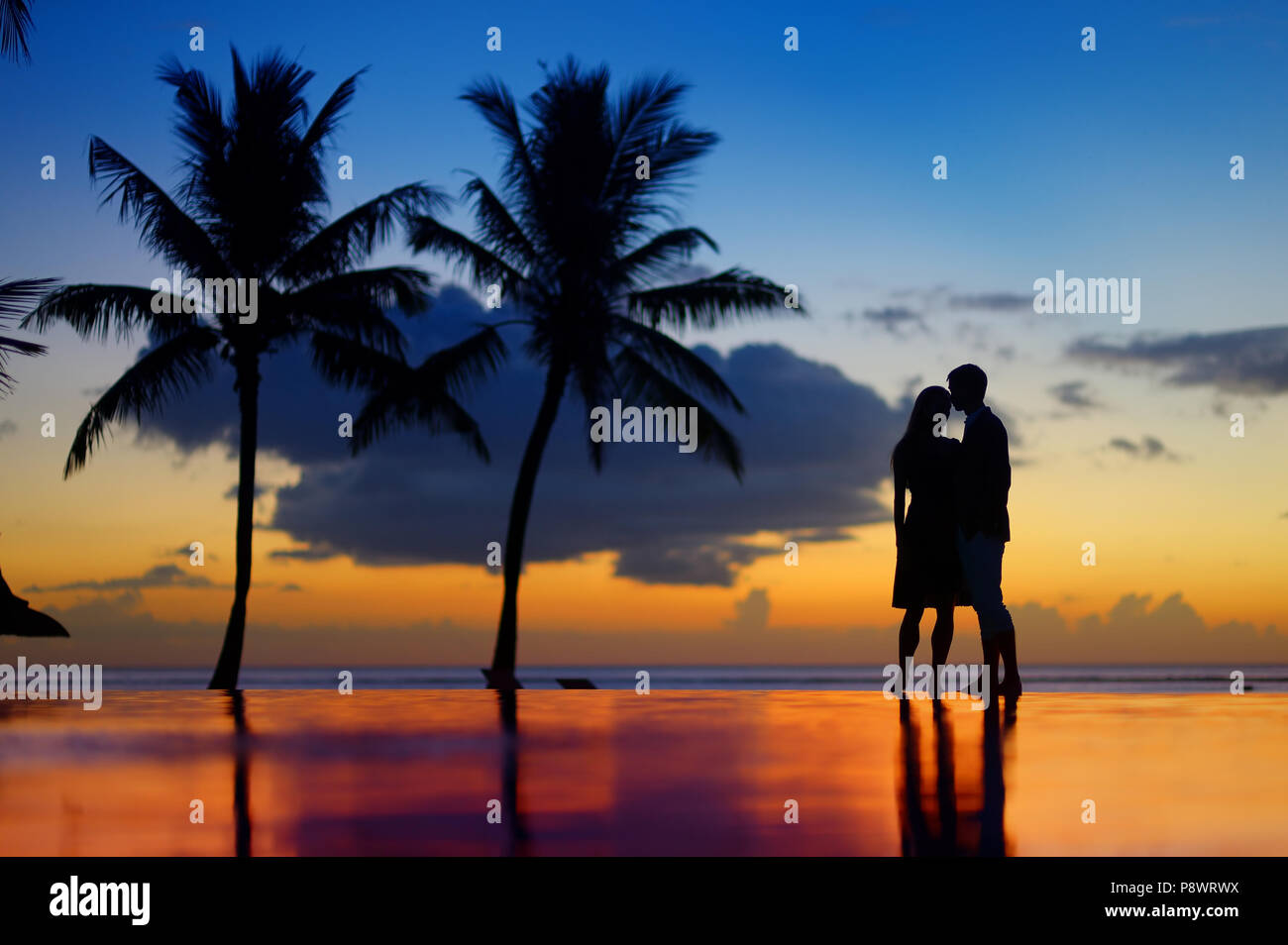 Silhouettes of young couple at scenic sunset on tropical beach Stock ...