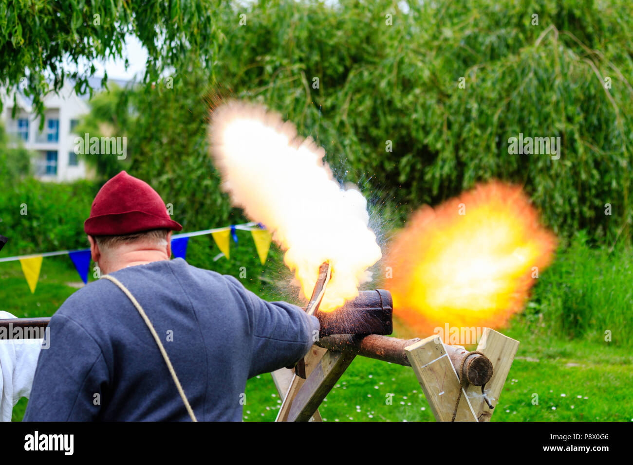 An early example of a German close-range hand cannon resting on wooden support being fired at medieval re-enactment event at Sandwich Stock Photo