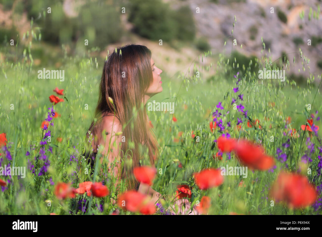 Beautiful Spring Young Woman Outdoors Enjoying Nature. Healthy Smiling Girl in flower Spring Meadow Stock Photo