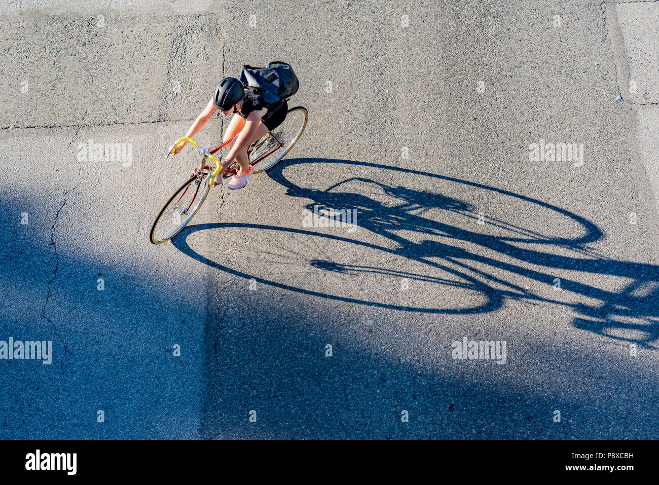 Cyclist and long shadow, Vancouver, British Columbia, Canada. Stock Photo