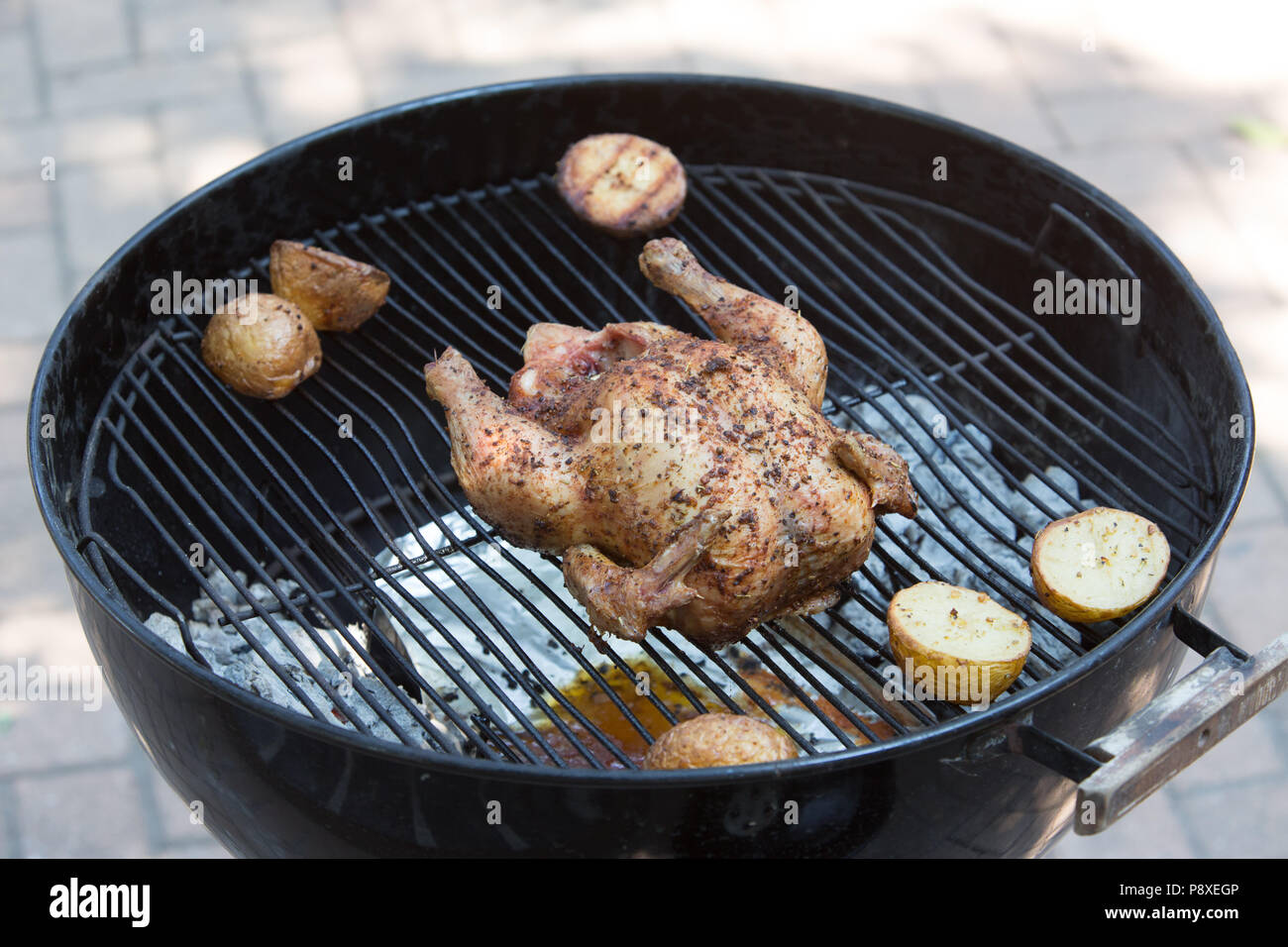 Weber kettle braai with roasted chicken and potatoes Stock Photo
