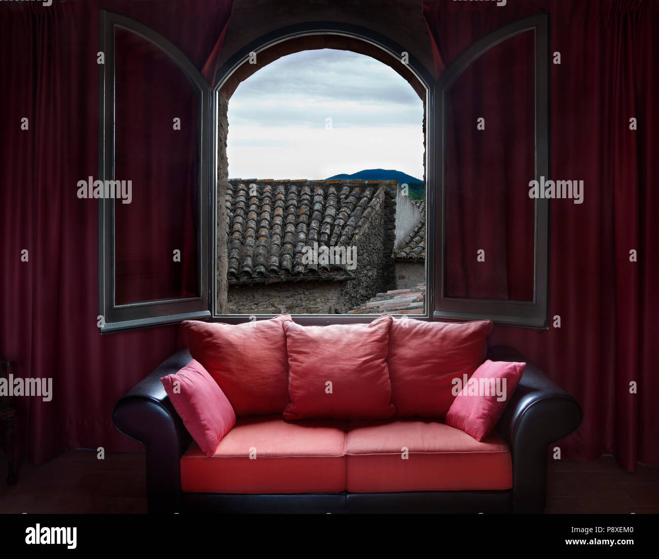 Interior detail couch and window with views of ancient roofs Stock Photo