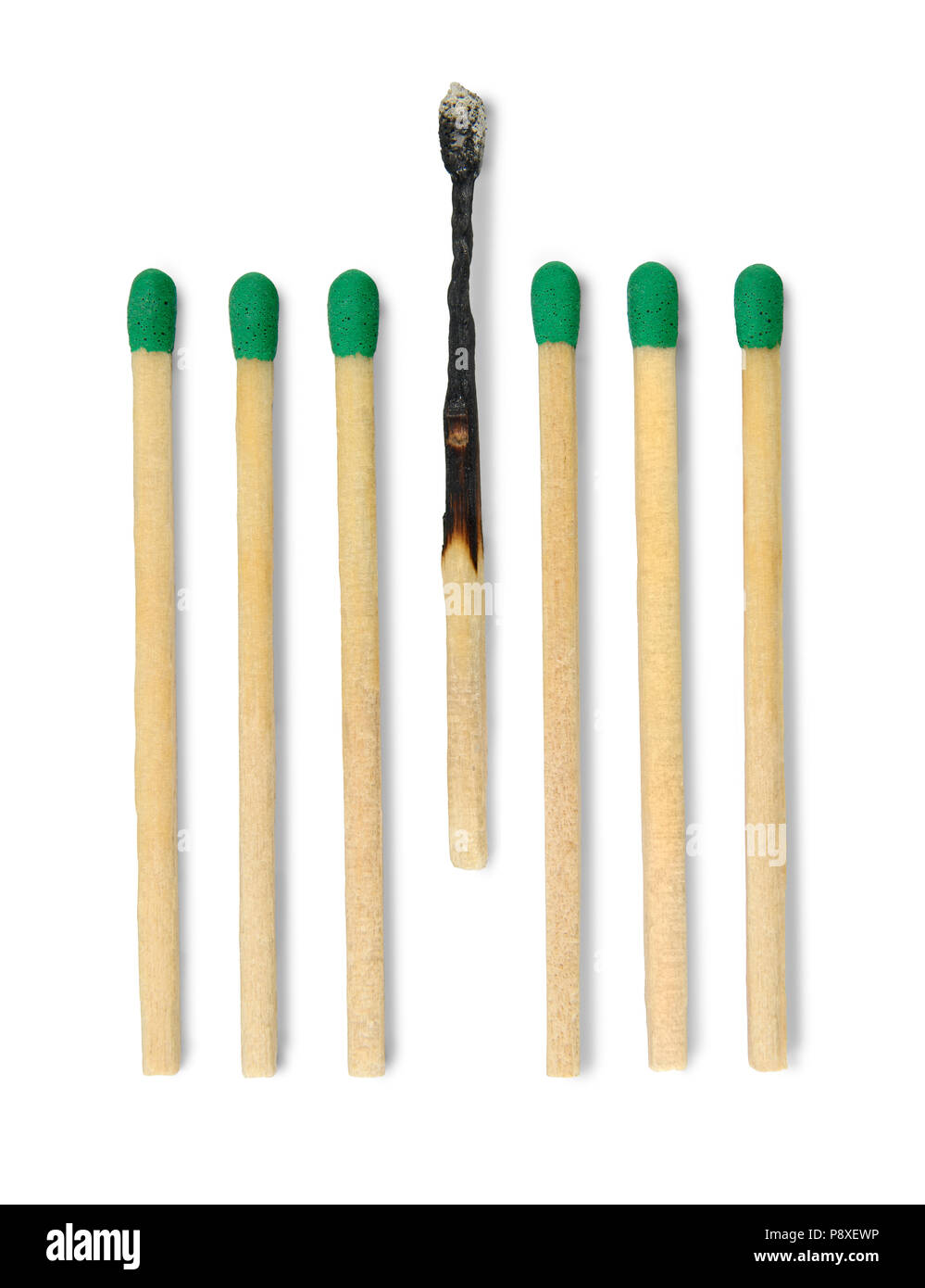 Seven matches one burnt in vertical position against white background. Stock Photo