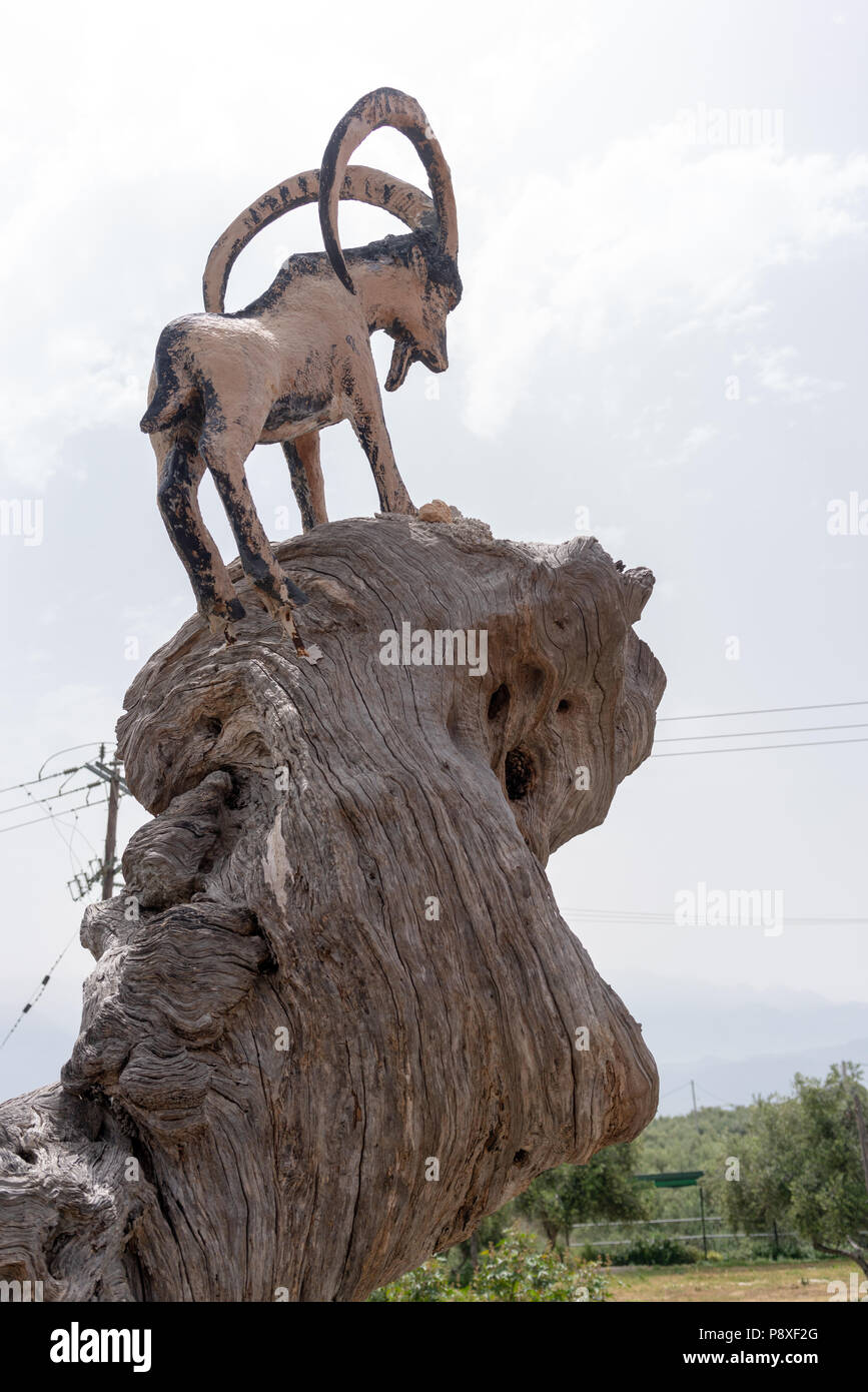 Statue of billy goat on a large rock at Koumos Stone House and restaurant at Kalyves Crete Stock Photo