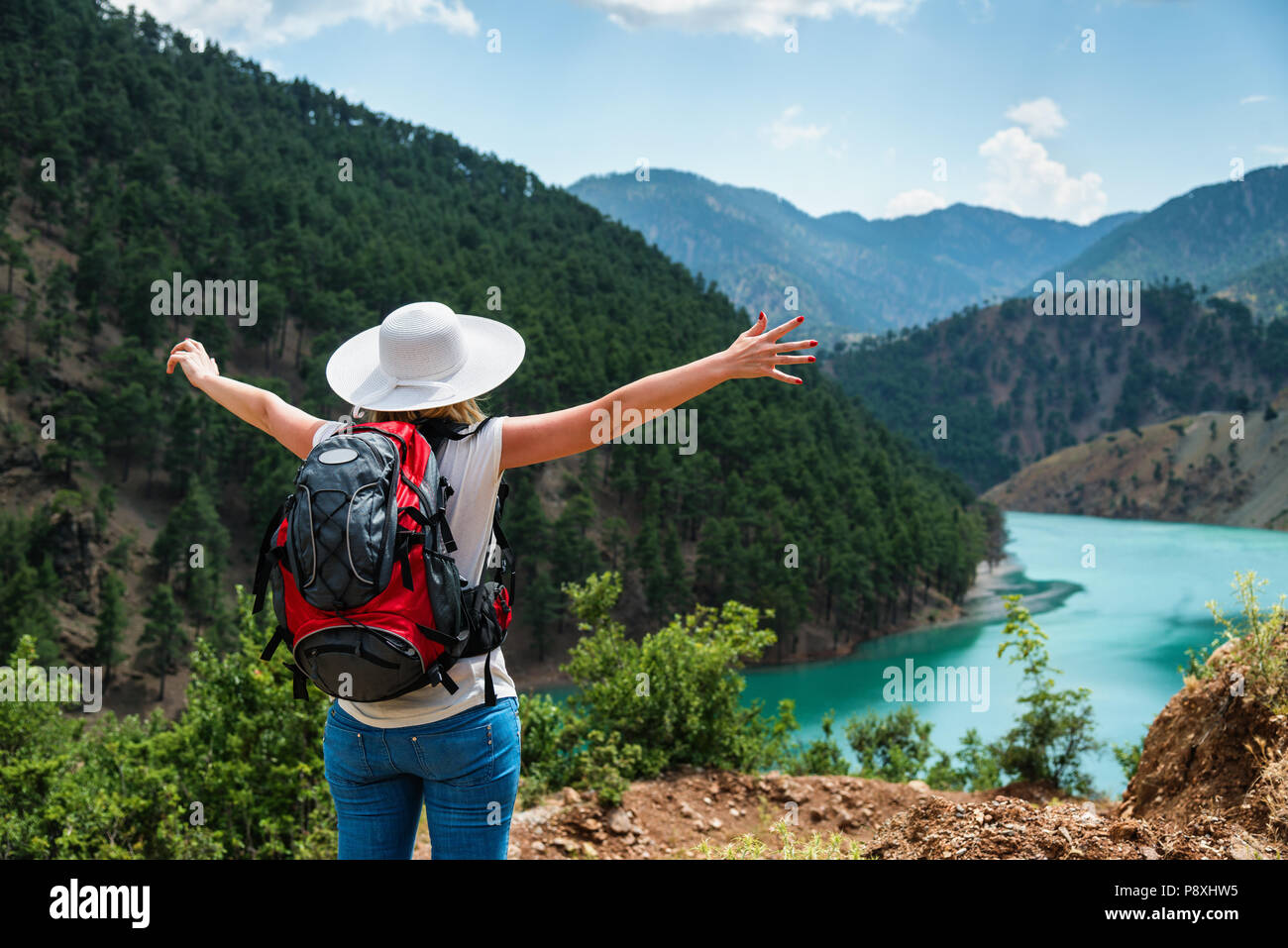 Woman traveler with backpack enjoying view Stock Photo