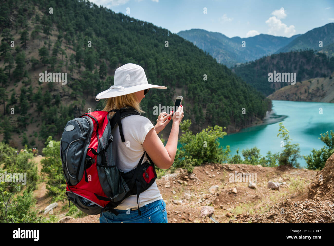 Woman backpacker using smart phone in mountains Stock Photo