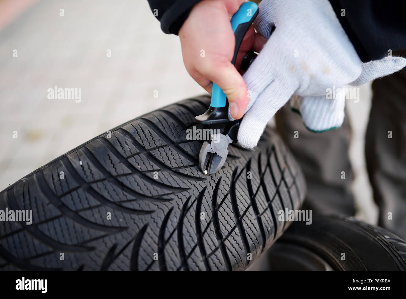 Pulling a nail out of tire Stock Photo - Alamy