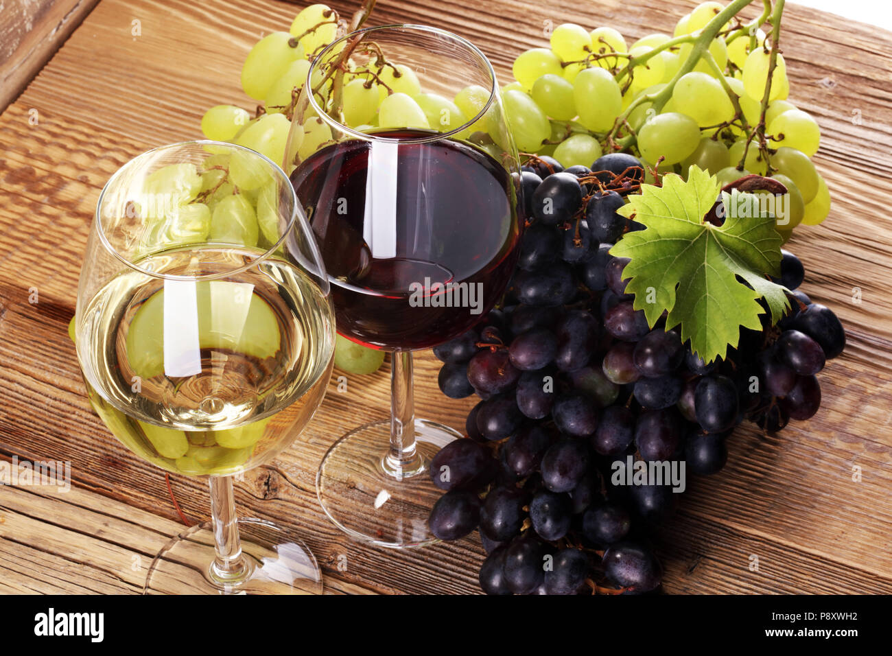Red Wine and white wine with grapes and glasses on rustic background Stock Photo