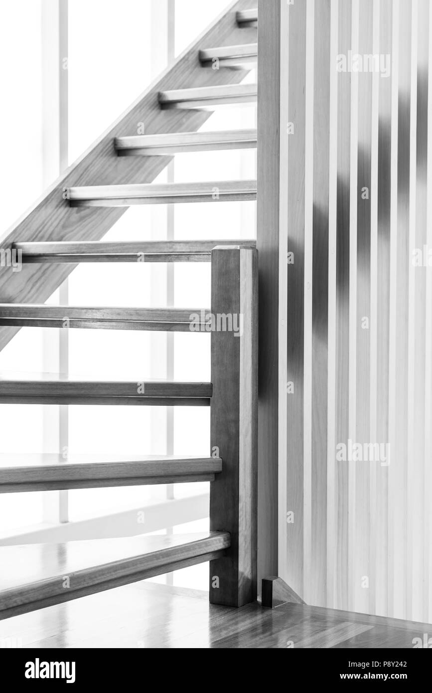 Indoor wooden staircase with light behind it in black and white Stock Photo