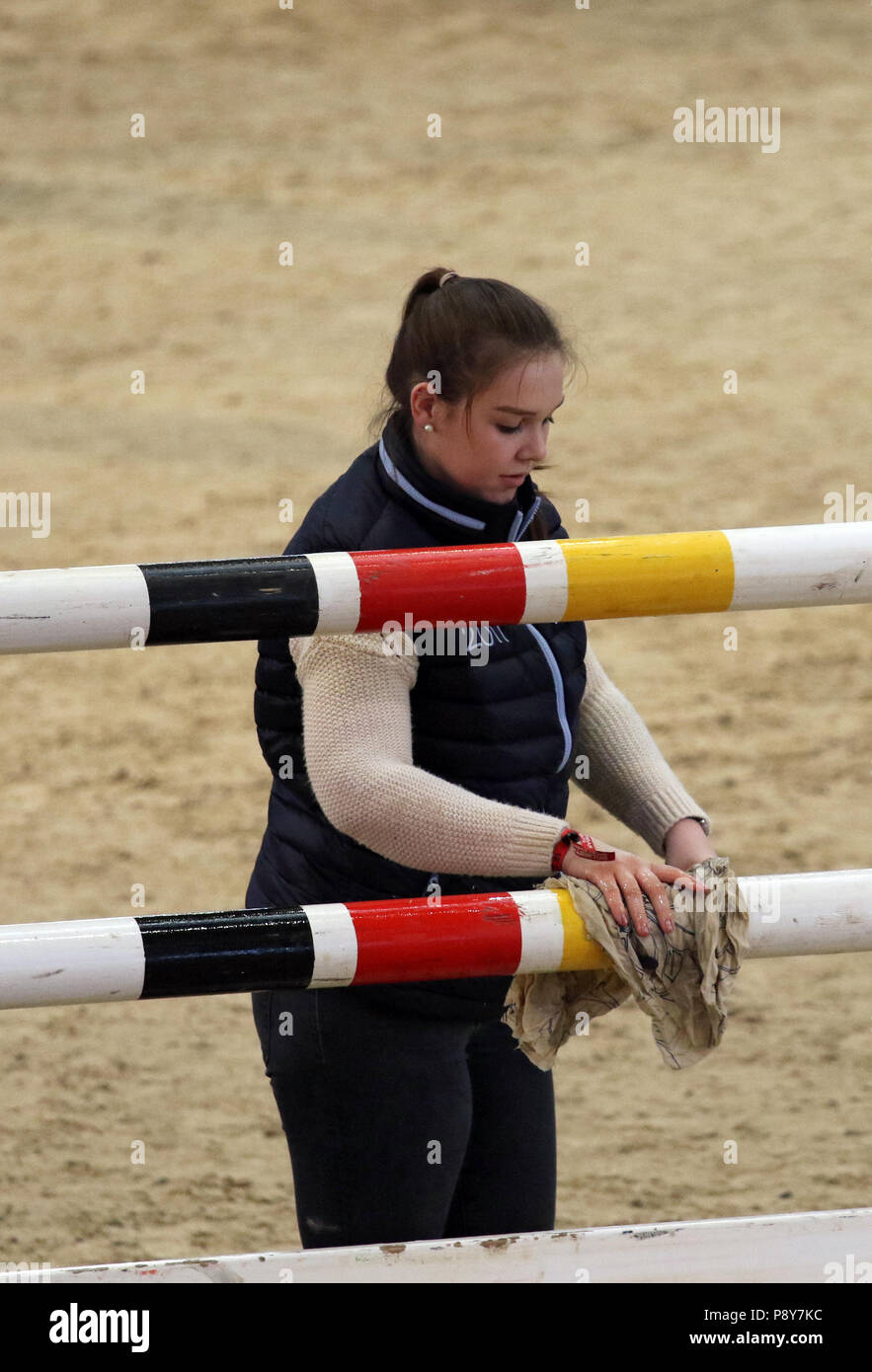 Neustadt (Dosse), girl cleans an obstacle rod in the show jumping course Stock Photo