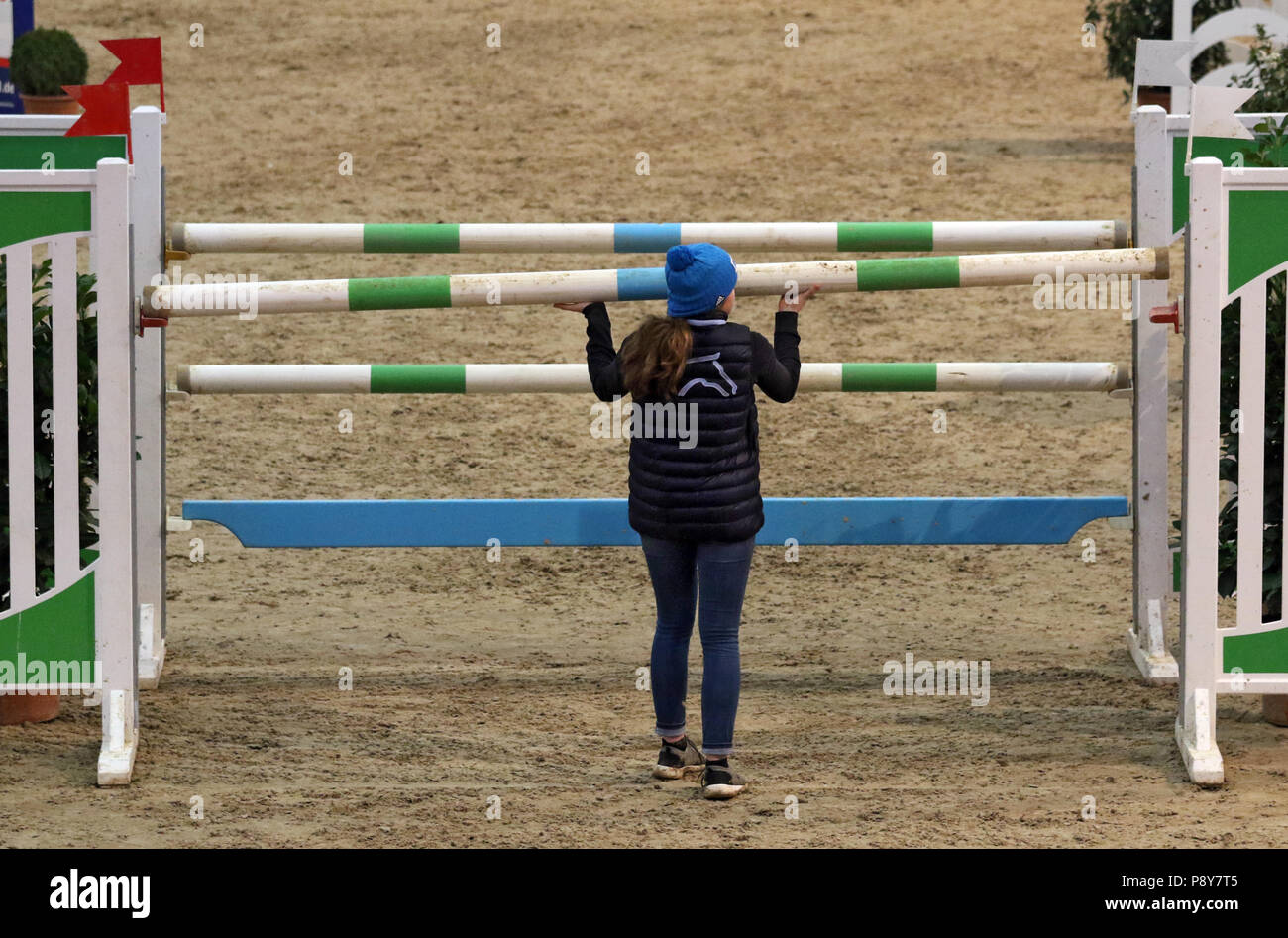 Neustadt (Dosse), girl puts an obstacle rod back in the brackets during show jumping Stock Photo