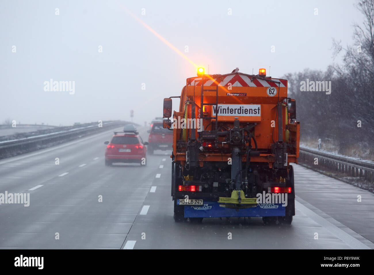 Leipzig, Germany, Winterdienst scatters on the highway A9 salt against Glaette Stock Photo