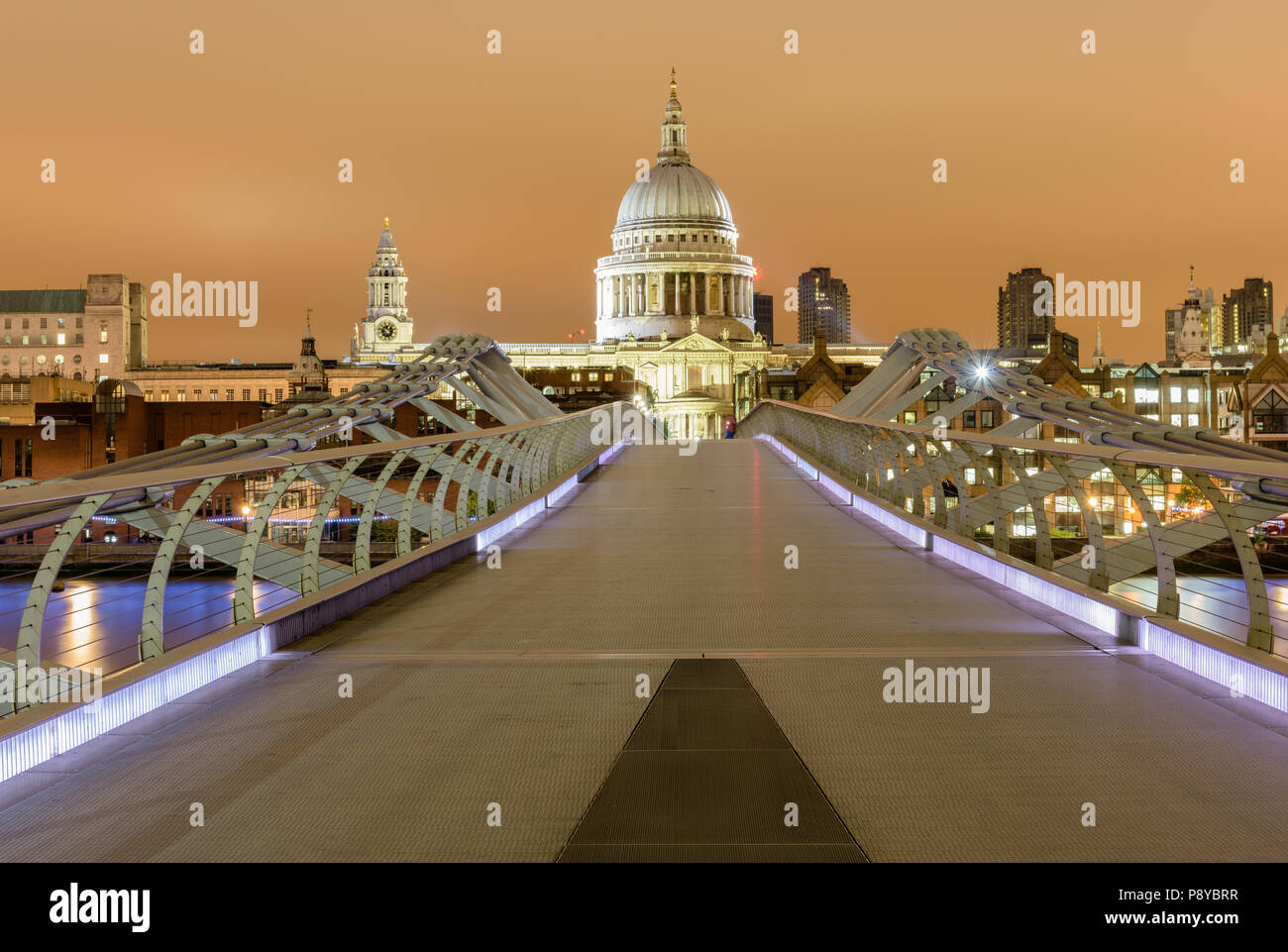 Head on landscape view of St Pauls Cathedral at night from a central position on the London Millennium Footbridge Stock Photo