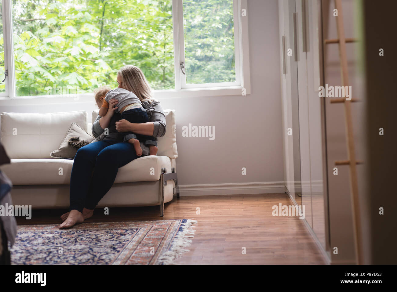 Mother playing with baby on the sofa Stock Photo