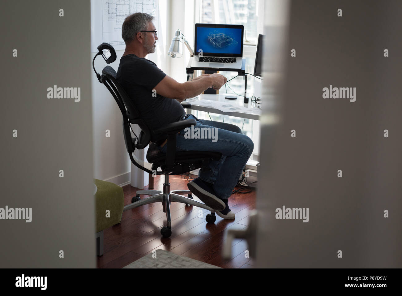 Man preparing architectural design on laptop at home Stock Photo