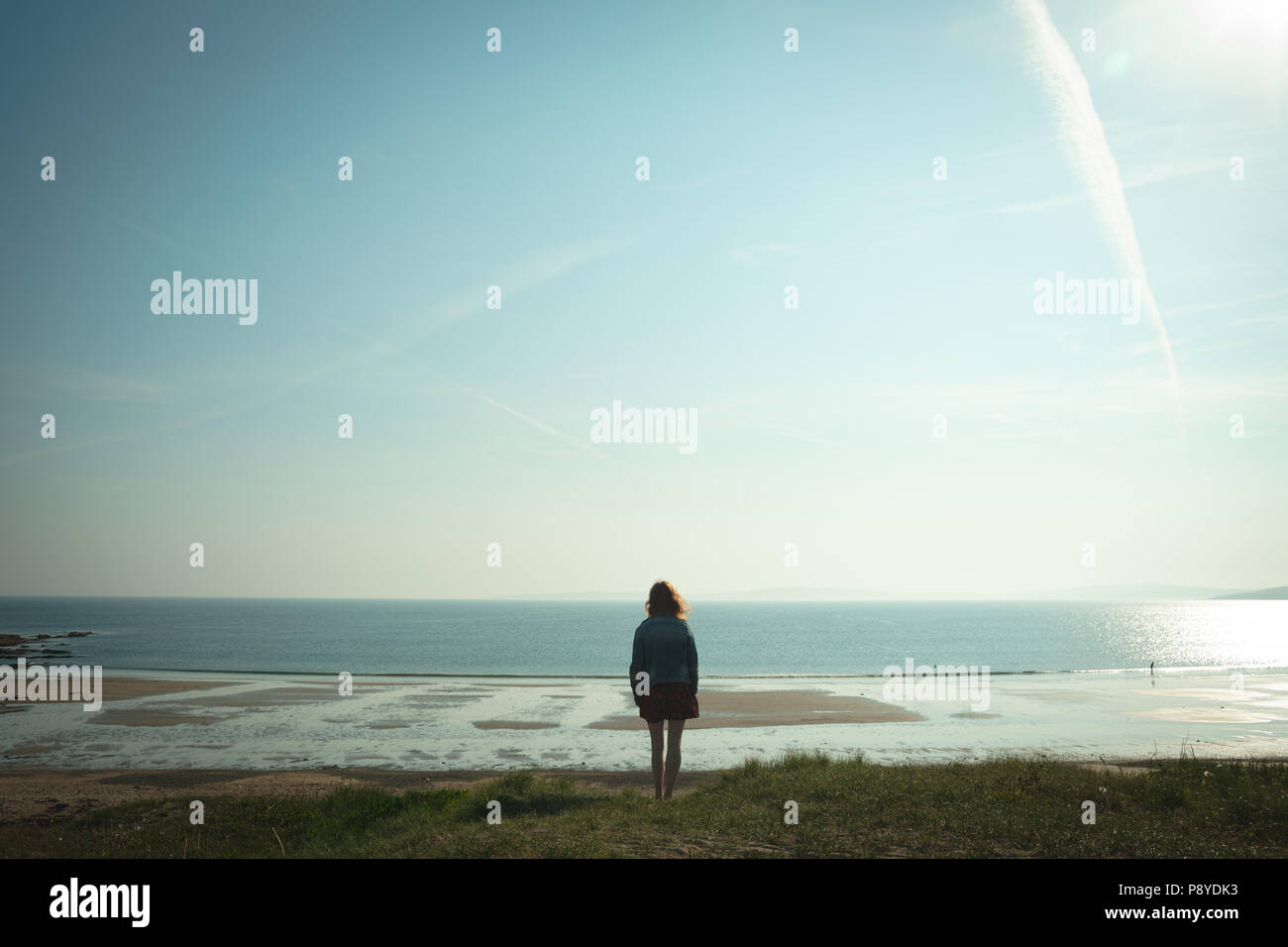 Woman standing on beach looking at sea hi-res stock photography and ...
