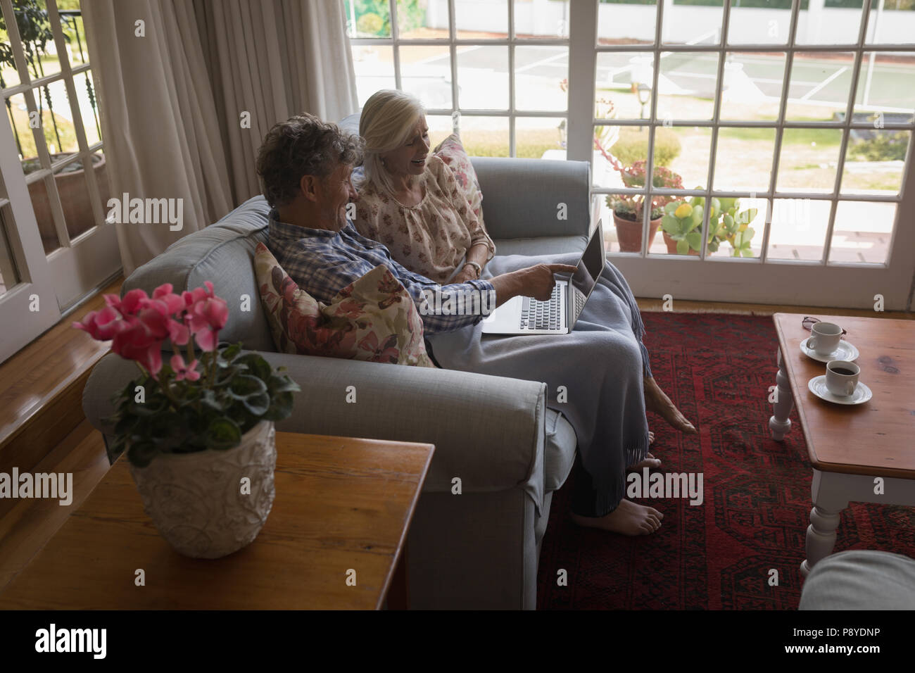 Senior couple using laptop on sofa Stock Photo