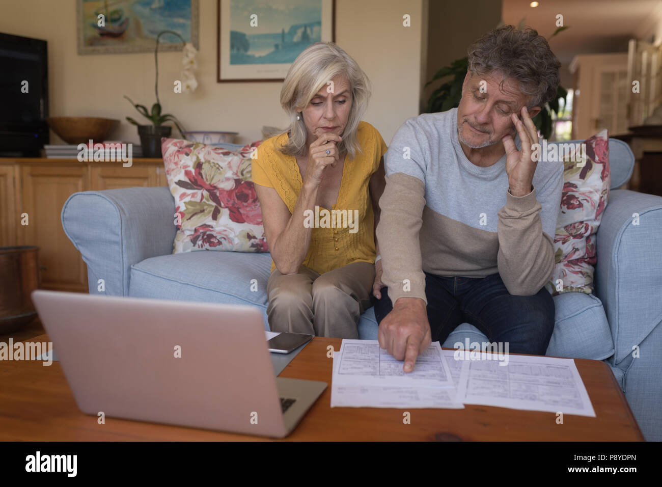 Worried senior couple discussing bills together Stock Photo