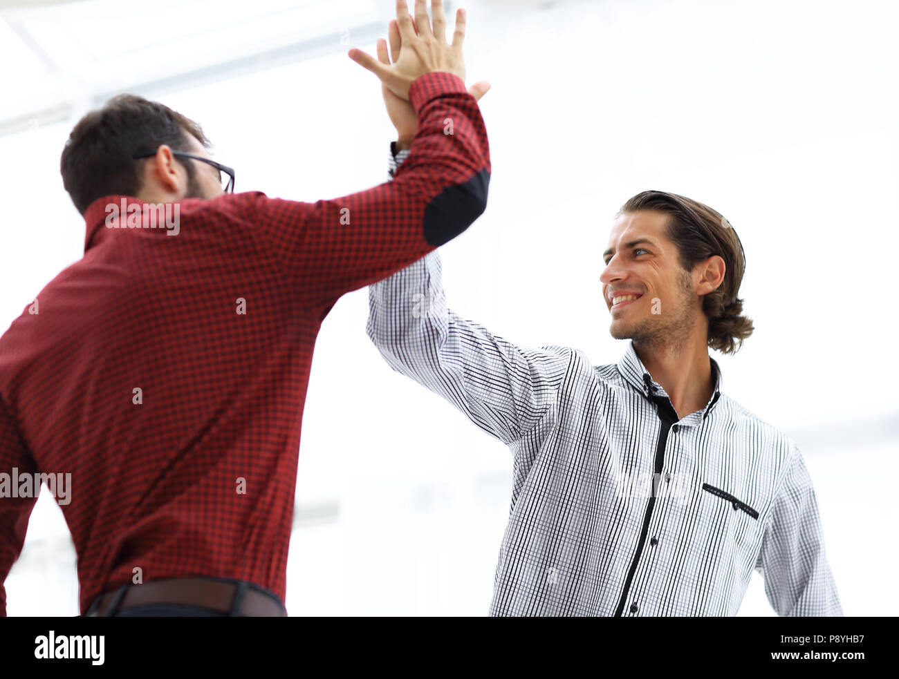 happy colleagues giving each other high five Stock Photo - Alamy