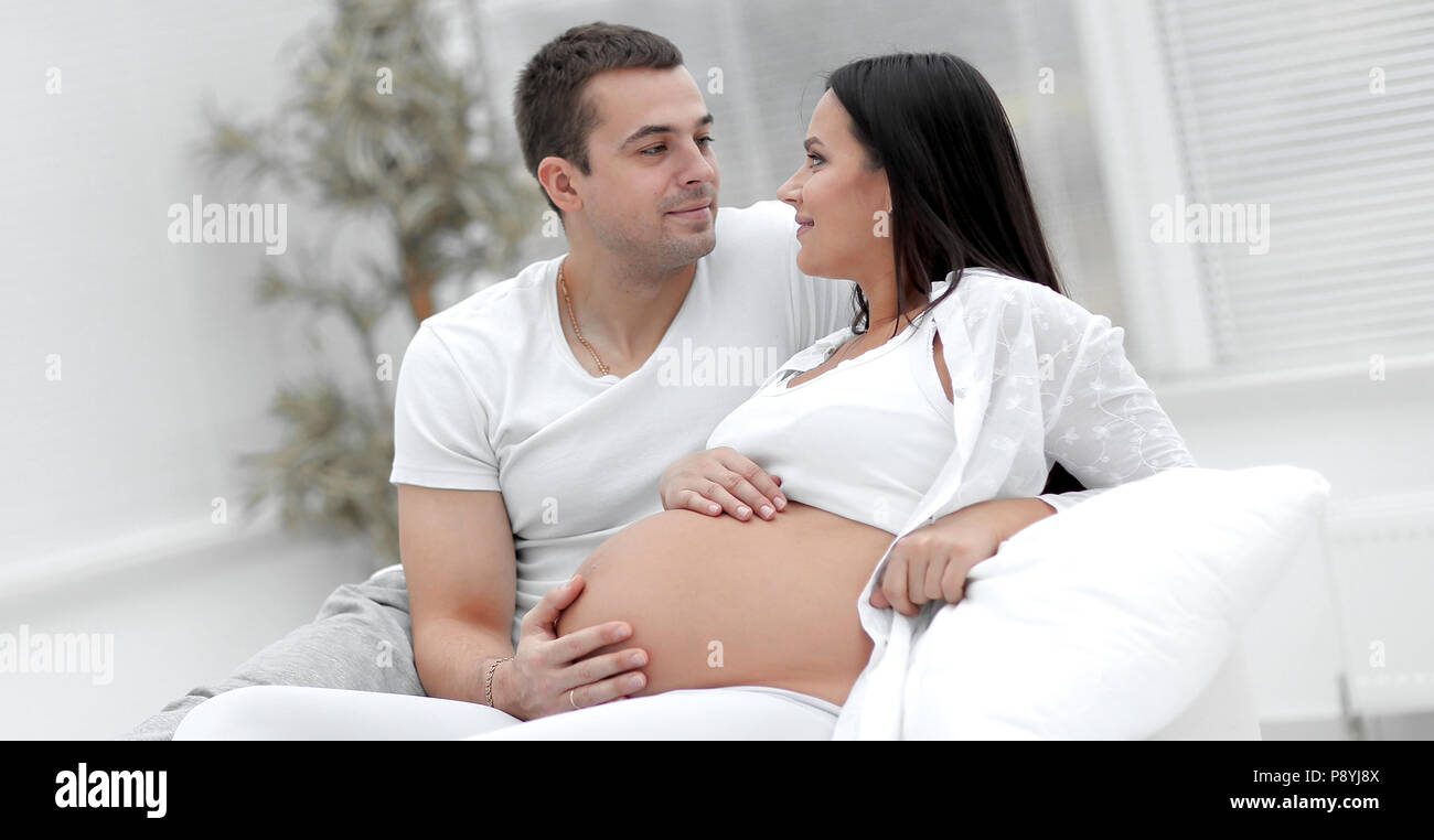 Husband And Pregnant Wife Lying On The Bed In The Bedroom